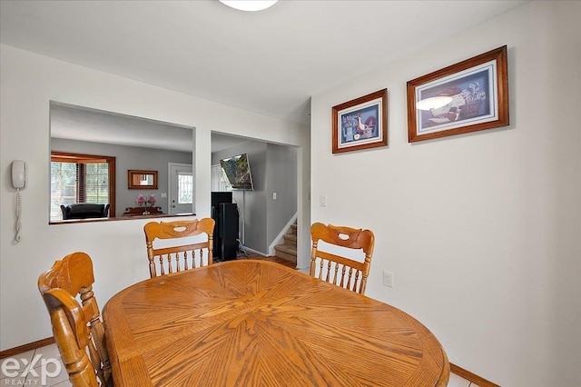dining room with baseboards and stairs