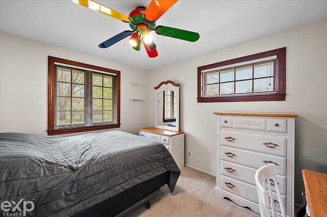 bedroom with a ceiling fan and light colored carpet