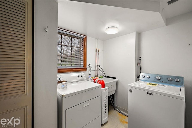 laundry room with a sink, light floors, laundry area, and washing machine and dryer