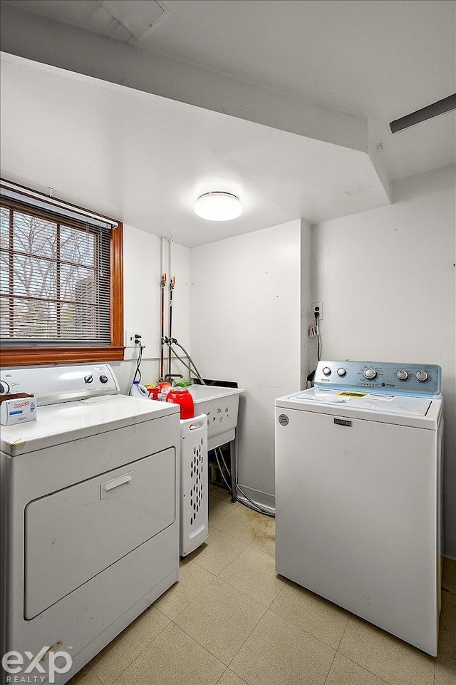 washroom featuring a sink, light floors, laundry area, and washing machine and dryer