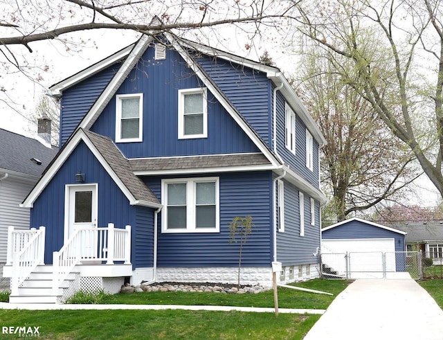 view of front of home featuring an outdoor structure, a garage, a front lawn, a shingled roof, and a gate
