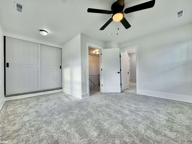 unfurnished bedroom featuring baseboards, a ceiling fan, carpet flooring, and visible vents