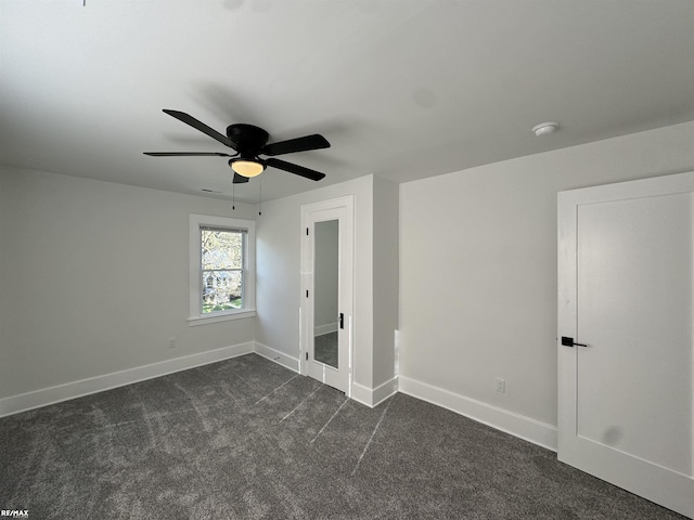 unfurnished bedroom featuring dark carpet, baseboards, and ceiling fan