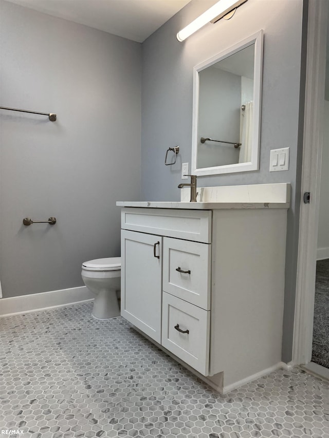 bathroom with vanity, baseboards, and toilet