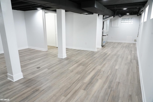 below grade area with baseboards and light wood-style flooring