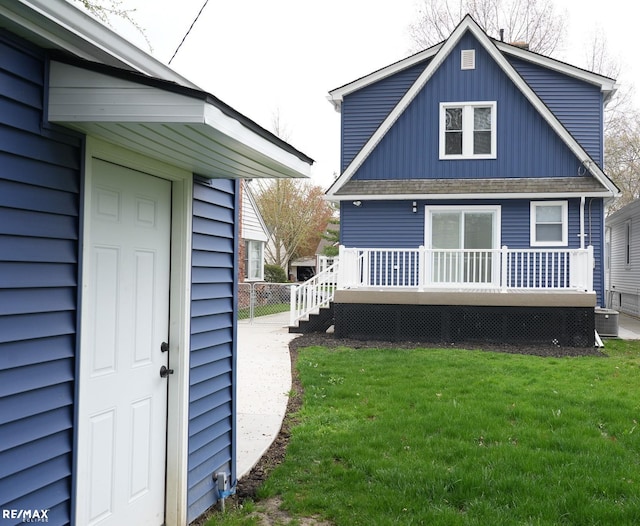 exterior space featuring board and batten siding, a yard, and a deck