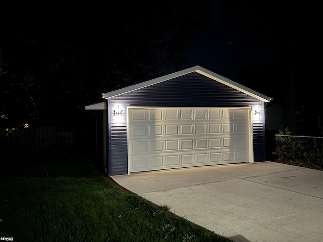 garage at night with a garage and fence