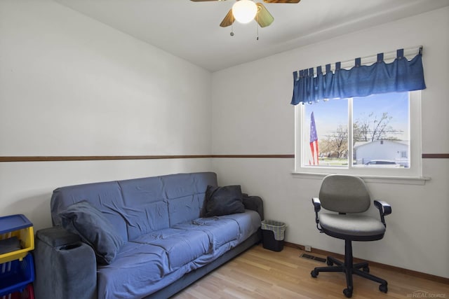 home office with a ceiling fan, baseboards, and wood finished floors