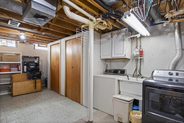 below grade area with a sink, light floors, and washer and clothes dryer