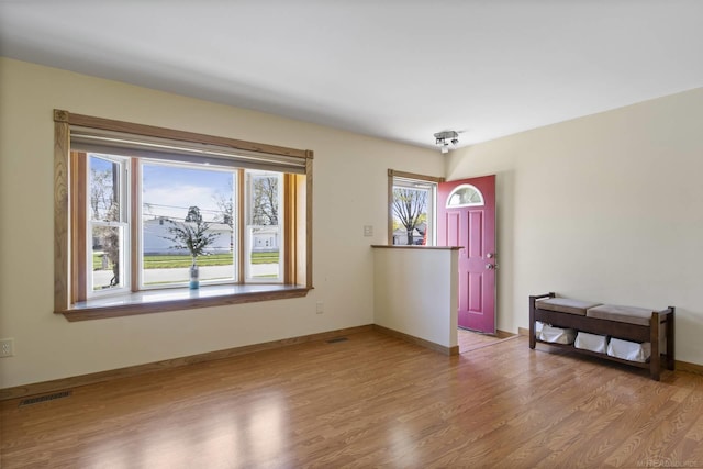 empty room with visible vents, baseboards, and wood finished floors