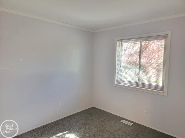 empty room with crown molding, baseboards, and dark colored carpet