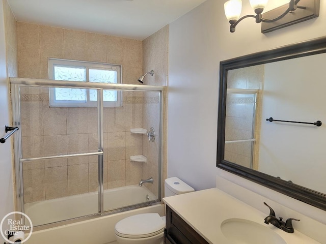 full bathroom featuring vanity, combined bath / shower with glass door, and toilet
