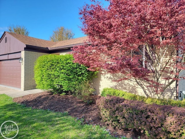 view of side of property featuring a garage and brick siding