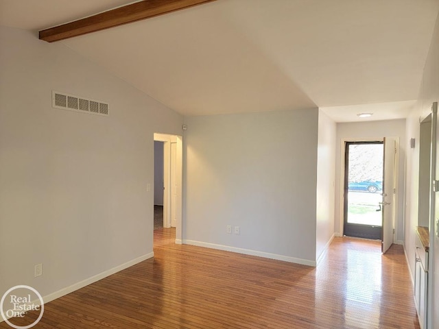 empty room with visible vents, baseboards, and light wood-type flooring