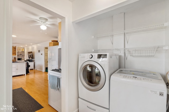 washroom featuring independent washer and dryer, ceiling fan, and light wood finished floors