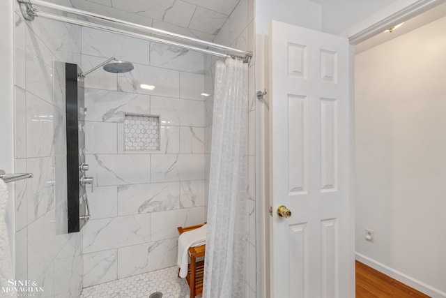bathroom with baseboards and a tile shower