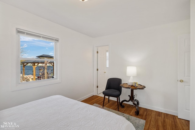 bedroom with baseboards and wood finished floors