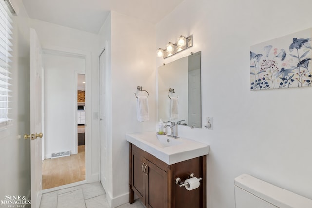 bathroom with toilet, baseboards, visible vents, and vanity