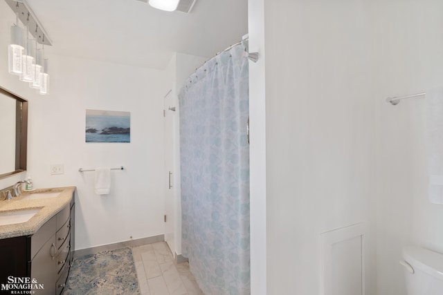 full bathroom with vanity, baseboards, and toilet