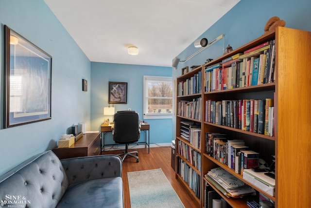 living area with baseboards and wood finished floors