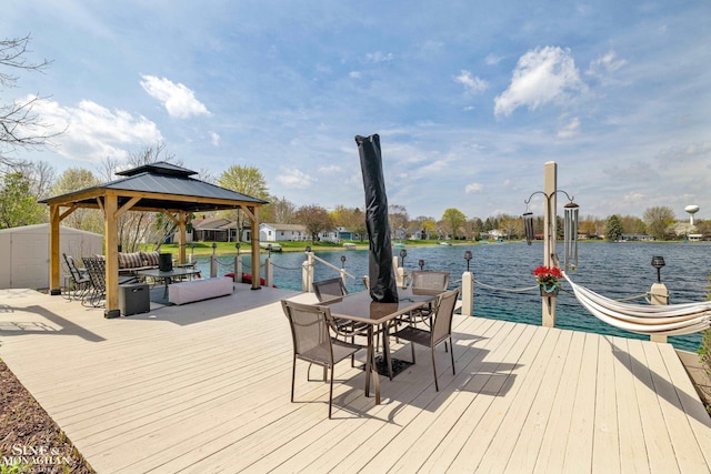 view of dock featuring a gazebo, a deck with water view, and outdoor dining space