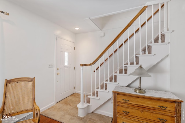 foyer with baseboards, recessed lighting, and stairs