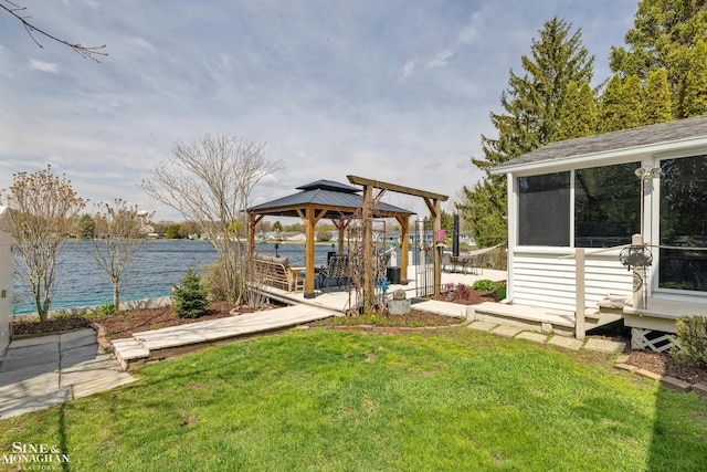 view of yard with a water view, a gazebo, fence, and a sunroom