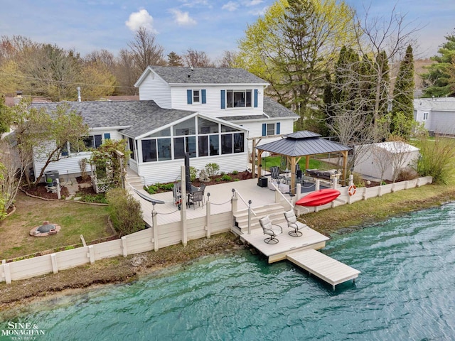 view of dock featuring a gazebo, a water view, fence, and a patio