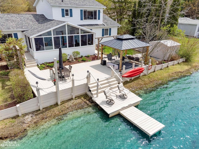 view of dock featuring a deck with water view and a gazebo