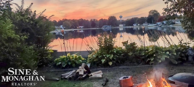 yard at dusk featuring a water view
