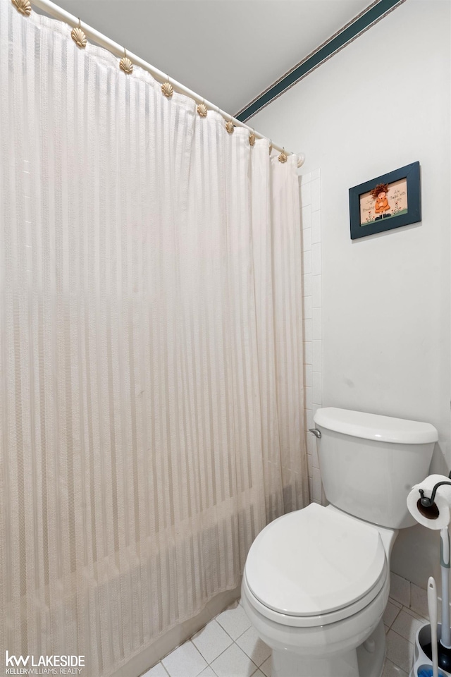 bathroom with toilet, tile patterned floors, and a shower with curtain