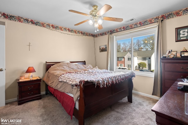 carpeted bedroom with baseboards, a ceiling fan, and visible vents