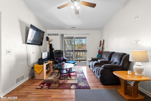 living room with a ceiling fan, lofted ceiling, wood finished floors, and visible vents