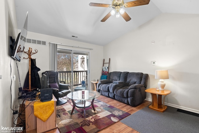 living room with visible vents, ceiling fan, wood finished floors, and vaulted ceiling