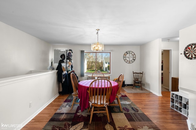 dining room featuring baseboards, a notable chandelier, and wood finished floors