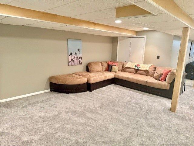 carpeted living room with baseboards