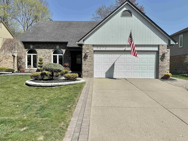 view of front of home featuring a garage, concrete driveway, brick siding, and a front yard