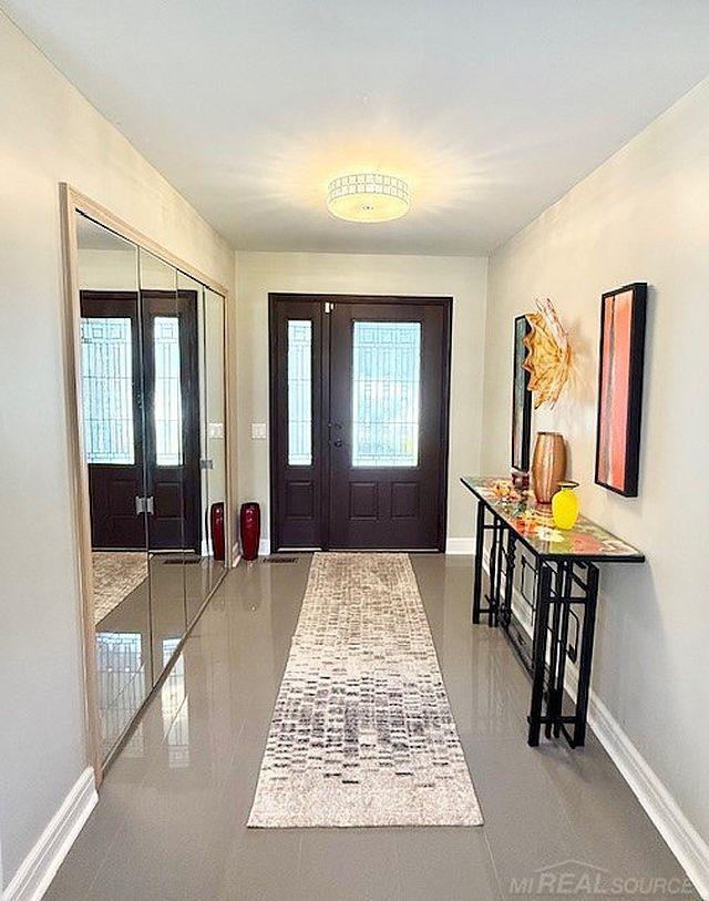 foyer entrance featuring baseboards and french doors