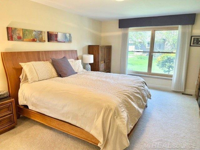 bedroom with baseboards and light carpet