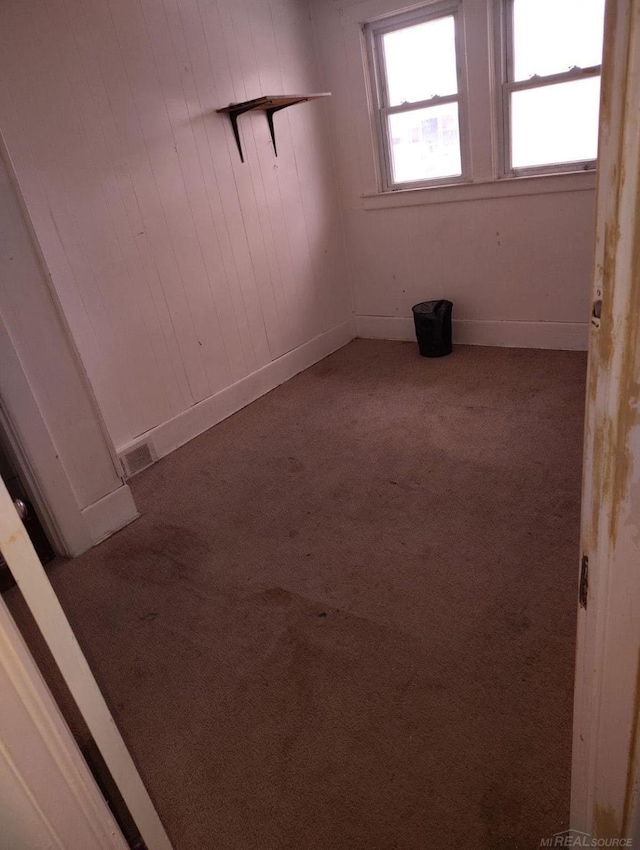 unfurnished room with carpet floors, baseboards, and visible vents
