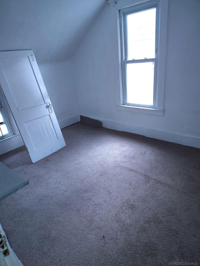 bonus room with carpet floors, baseboards, a wealth of natural light, and lofted ceiling