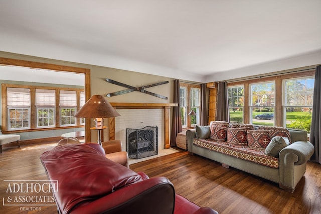 living area with a brick fireplace and hardwood / wood-style flooring