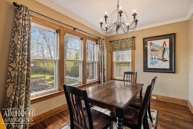 dining area with crown molding, baseboards, wood finished floors, and a notable chandelier