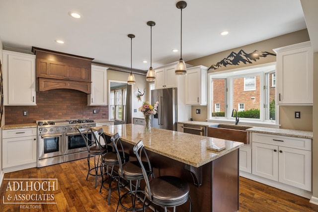 kitchen featuring backsplash, high quality appliances, a sink, white cabinets, and custom exhaust hood