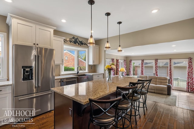 kitchen with a center island, a sink, appliances with stainless steel finishes, and white cabinets