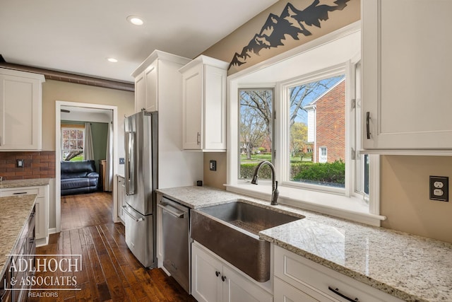 kitchen featuring appliances with stainless steel finishes, a sink, recessed lighting, white cabinetry, and dark wood-type flooring