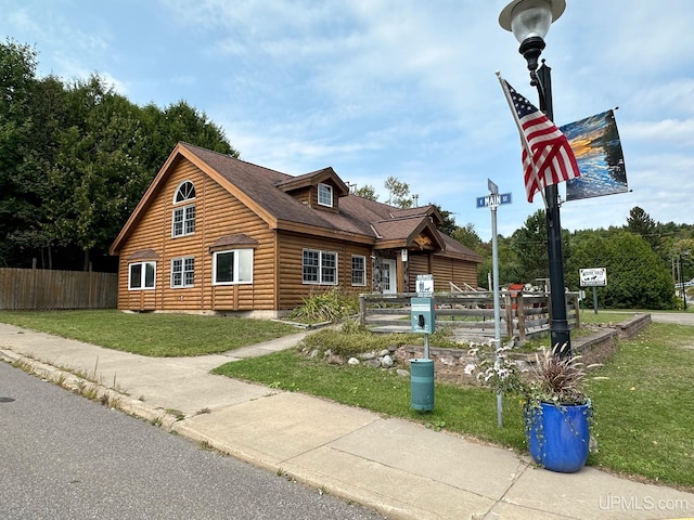 view of front of house featuring fence and a front yard