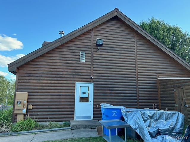 rear view of house featuring log veneer siding