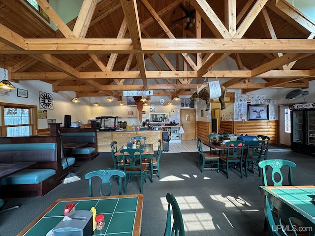 dining room with carpet flooring, high vaulted ceiling, and beamed ceiling