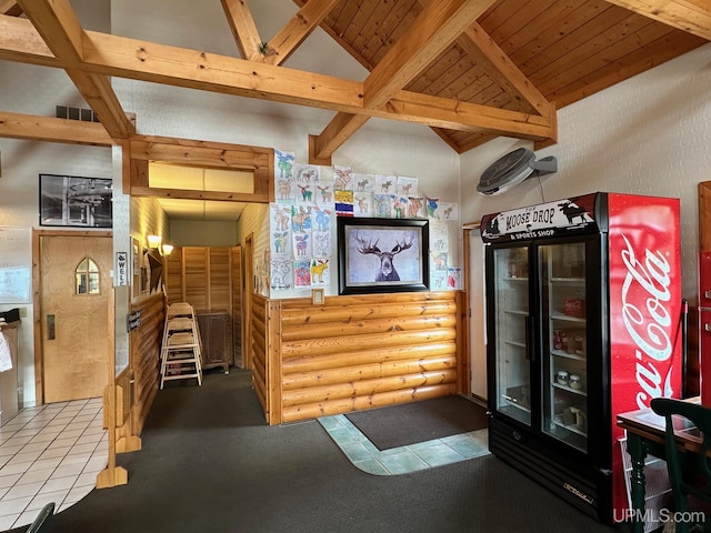 interior space with vaulted ceiling with beams and rustic walls